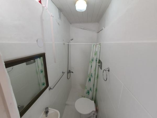 y baño blanco con ducha y aseo.  en Daireaux en Villa Gesell
