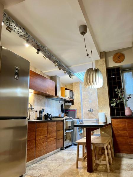 cocina con refrigerador de acero inoxidable y mesa en Confortable y acogedor en un lugar único en Palermo en Buenos Aires