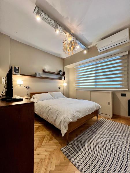 1 dormitorio con 1 cama, TV y ventana en Confortable y acogedor en un lugar único en Palermo en Buenos Aires