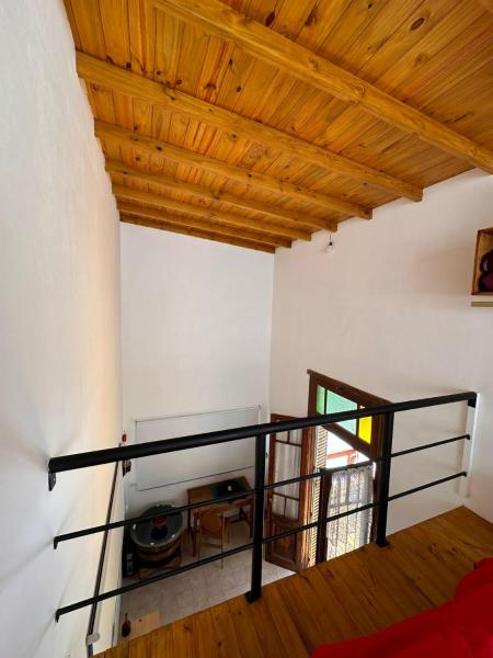 Habitación con techo de madera y barandilla negra.  en Plumerillos aparte en Mar de las Pampas
