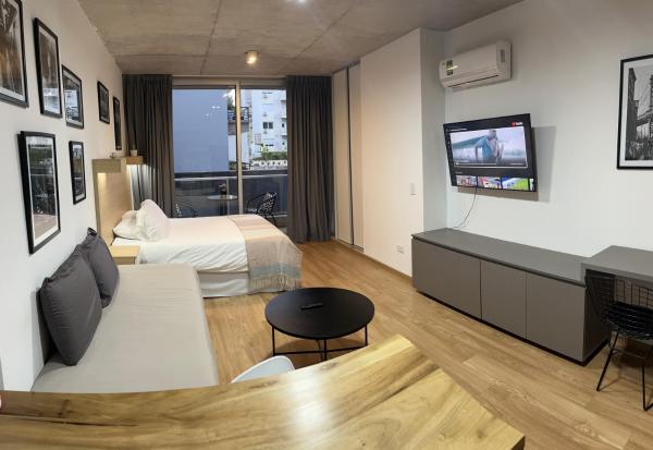 Habitación de hotel con cama y TV en CloudBA Fitz Roy Apartments en Buenos Aires