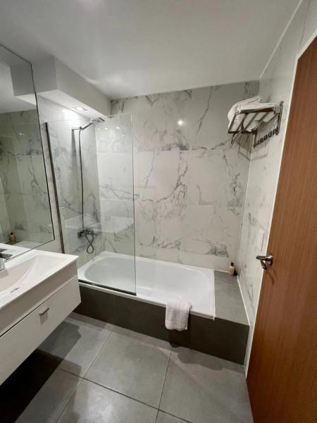 y baño con ducha, bañera y lavamanos. en CloudBA Fitz Roy Apartments en Buenos Aires
