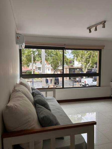 sala de estar con sofá y ventana grande en Hermoso departamento en Aristides Villanueva en Mendoza