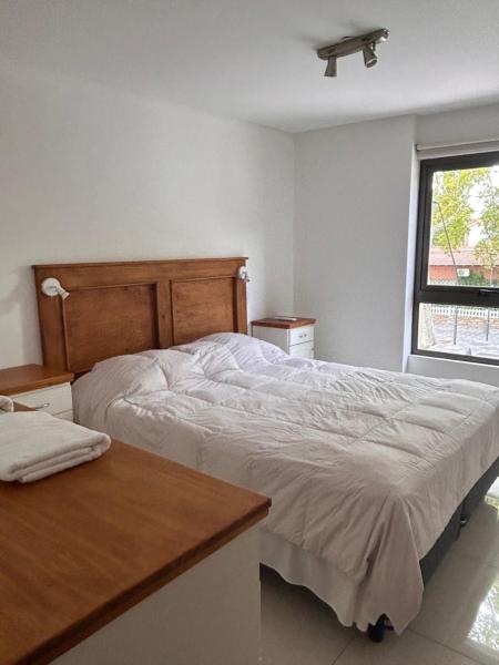 1 dormitorio con cama, escritorio y ventana en Hermoso departamento en Aristides Villanueva en Mendoza