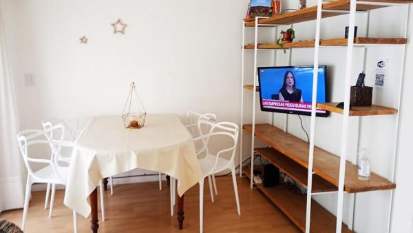 comedor con mesa y TV en un estante en Departamento en Palermo dos dormitorios para 5 con balcón en Buenos Aires