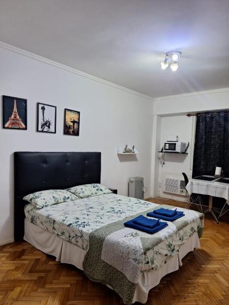 Un dormitorio con una cama con toallas azules. en Departamento en Congreso en Buenos Aires
