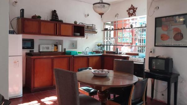 cocina con mesa de madera con sillas, mesa y TV en Gachishouse en Buenos Aires