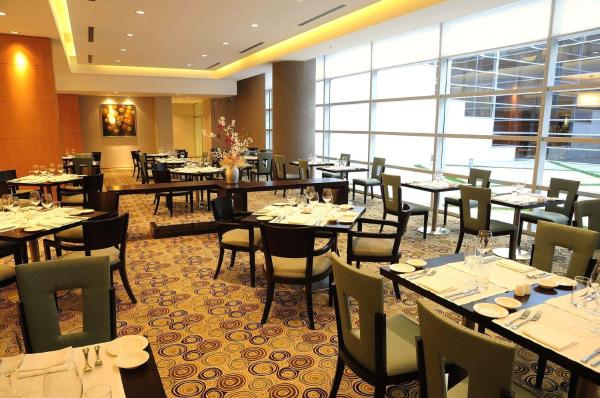 un restaurante con mesas y sillas y una gran ventana en Hilton Mendoza en Mendoza