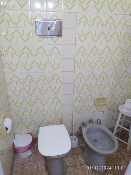 y baño con aseo y lavamanos. en La casa en Gualeguaychú