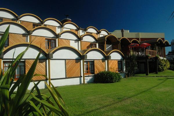 una gran casa blanca con tejado azul en la Hostería Querandi de Villa Gesell