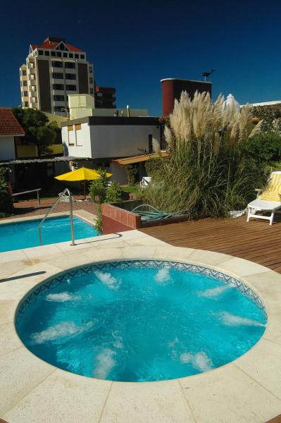 una piscina con una mesa de billar frente a un edificio de la Hostería Querandi en Villa Gesell