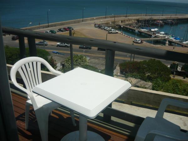 a white table and chair on a balcony overlooking a highway at Amarras Reales in Piriápolis