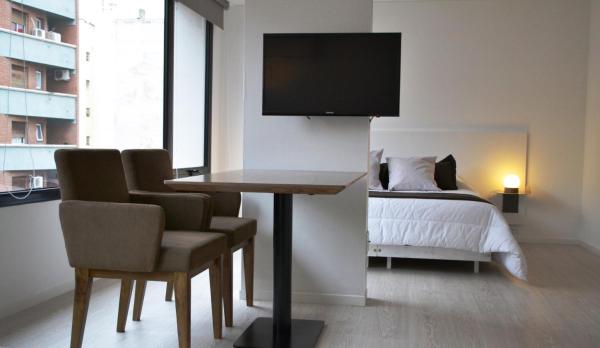 Una televisión o centro de entretenimiento en Departamentos Rondeau By Lugar