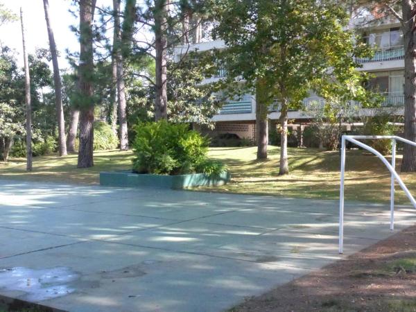 un campo de fútbol en un parque con árboles y un edificio en Arcobaleno en Punta del Este, en Punta del Este