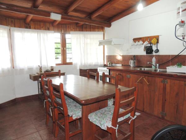 cocina con mesa de madera y sillas en Cabañas Gesell en Villa Gesell