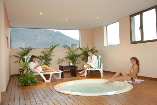 un grupo de personas sentadas en sillas alrededor de una bañera de hidromasaje en Hotel Ankara Suites en Salta