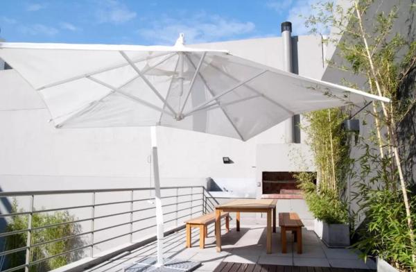 una sombrilla blanca en un patio con mesa y sillas en Funky & Stylish Apartment Palermo en Buenos Aires