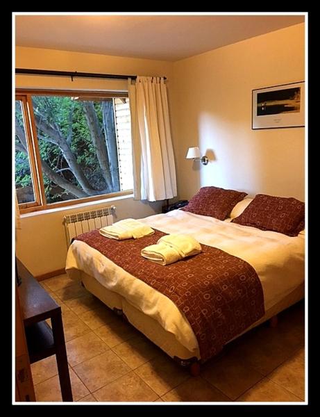 Habitación de hotel con 2 camas y ventana en Departamento de Alquiler Turistico en San Martín de los Andes