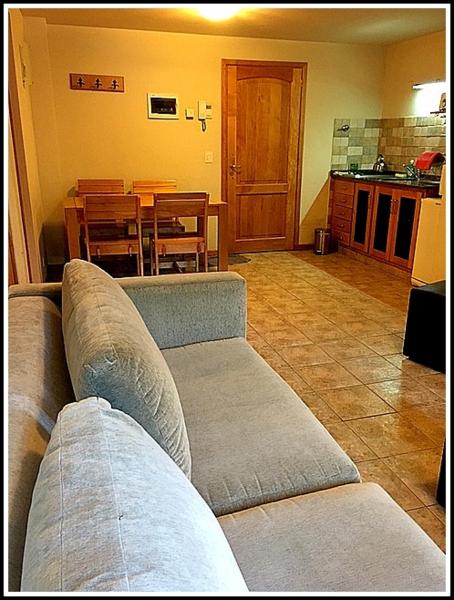 sala de estar con sofá y mesa en Departamento de Alquiler Turistico en San Martín de los Andes