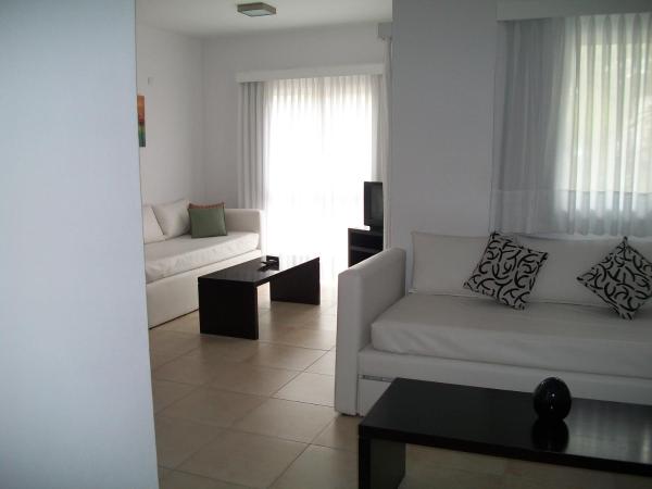 Sala de estar blanca con sofá y mesa en Avutarda de Carilo en Cariló