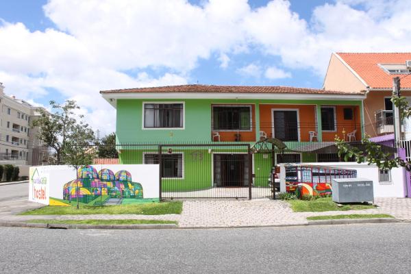 a green and white building with graffiti on the side of it at Curitiba Casa Hostel in Curitiba