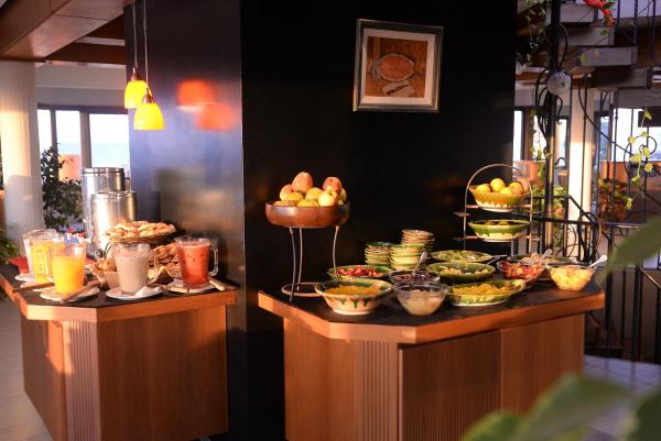 una línea de buffet con cuencos de fruta y otros alimentos en Hostería Tequendama Classic & Resort en Villa Gesell