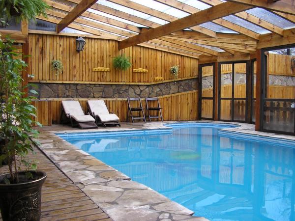 una piscina en una casa con techo de madera en Apart Cascadas en San Martín de los Andes