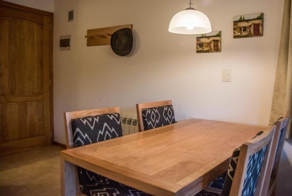 comedor con mesa de madera y sillas en Altos de la Montaña en San Martín de los Andes