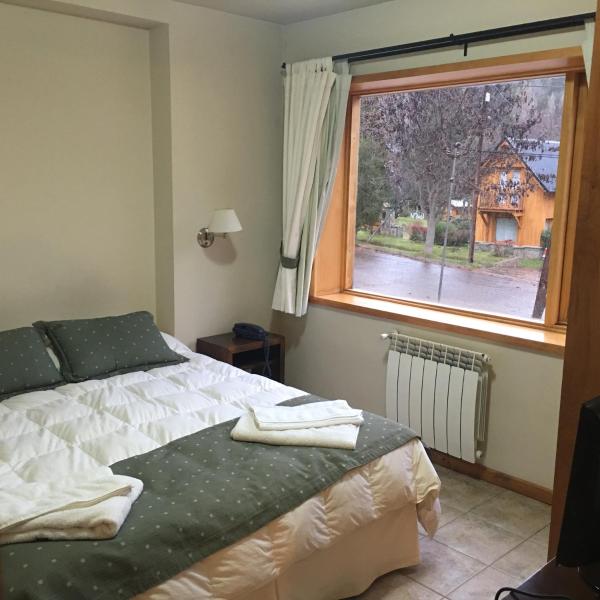 1 dormitorio con cama y ventana en Departamento de Alquiler Turistico en San Martín de los Andes