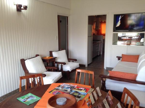 una sala de estar con mesa y sillas en YAI Departamentos en Villa Gesell