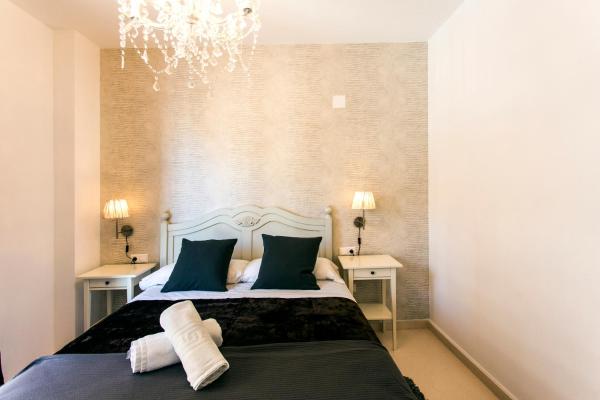 1 dormitorio con 1 cama con 2 mesas y una lámpara de araña en Total Valencia Old City Luxury, en Valencia