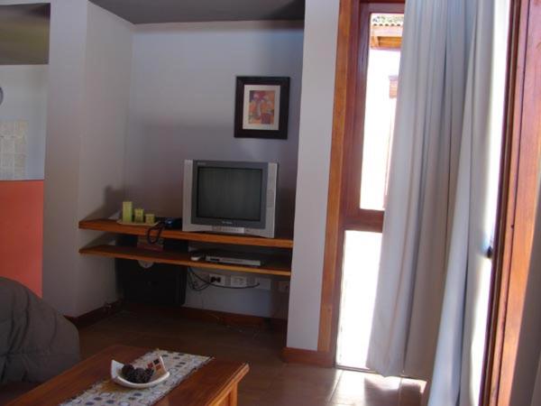una sala de estar con un televisor sobre una mesa en Cabañas Arenas Blandas de Villa Gesell