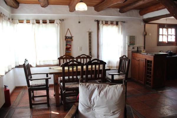 cocina y comedor con mesa y sillas en Cabañas Patagonia en Villa Gesell