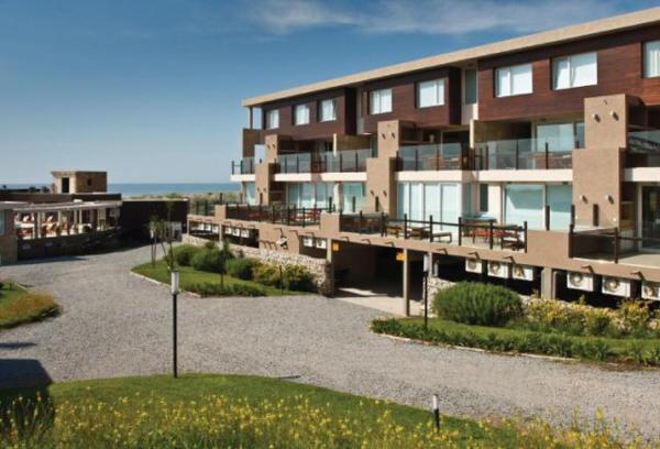 un gran edificio de apartamentos con muchas ventanas en Linda Bay Beach & Resort en Mar de las Pampas