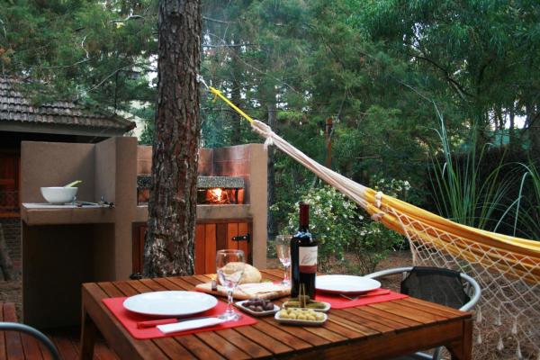 una mesa con una botella de vino en una hamaca en Kaia Apart y Spa en Mar de las Pampas