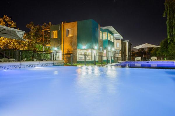 una piscina frente a una casa por la noche en Complejo Turístico Las Catalpas, en Mina Clavero