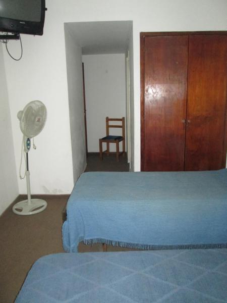 1 dormitorio con 1 cama, ventilador y silla en Hotel Perla Central en Mar del Plata