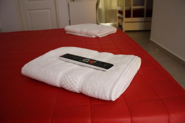 un mando a distancia sentado sobre una toalla blanca en cama en Agua De Coco en Villa Gesell