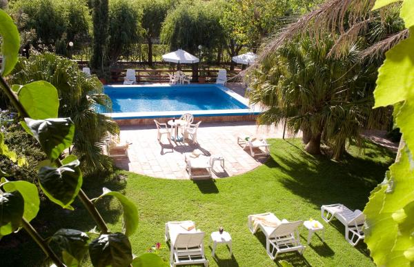 un patio trasero con una piscina con sillas y una mesa en Hotel Riviera en Villa Gesell