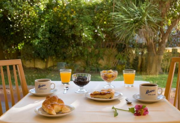- Mesa con desayuno de cruasanes y zumo de naranja en Hotel Riviera en Villa Gesell