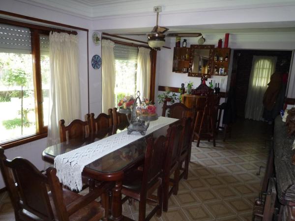 comedor con mesa y sillas y cocina en Chalet familiar adosado Roses Rojas en Villa Gesell