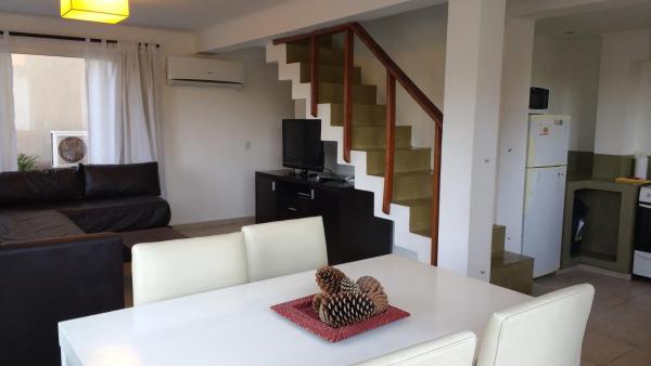 una sala de estar con una mesa blanca con sillas y una escalera.  en Jaina Resort & Spa en Mar de las Pampas
