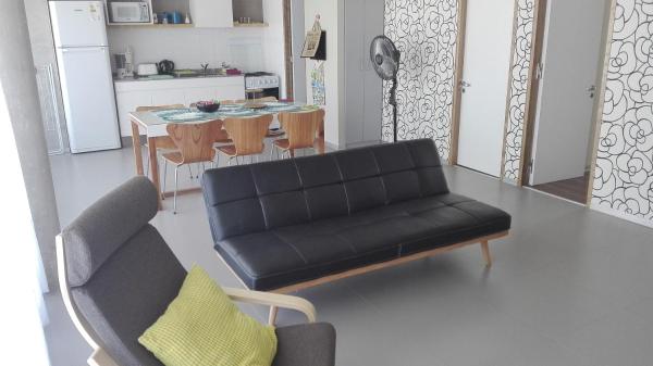 sala de estar con sofá negro y cocina en Marina Piccola en Ostende