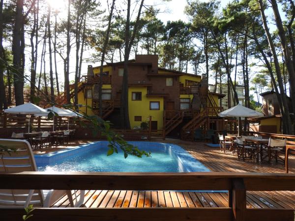 una piscina con una casa al fondo en Barlovento Apart & Spa en Mar de las Pampas