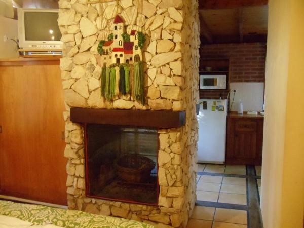 sala de estar con chimenea en la cocina en Cabañas El Ocio, en Mar de las Pampas