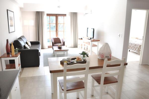 cocina y sala de estar con mesa y sillas en Green Sea Apart Hotel en Pinamar