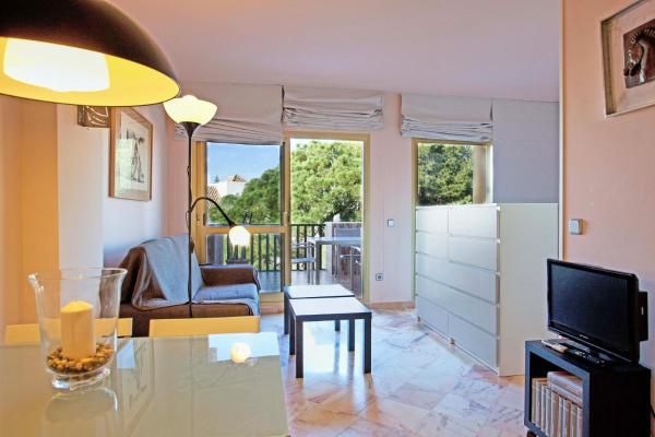 sala de estar con mesa y TV en Romana Playa Studio, en Marbella