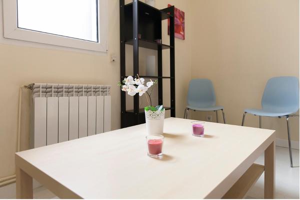 Una mesa blanca con un jarrón de flores.  en For You Rentals parque del retiro apartment LDR28, en Madrid