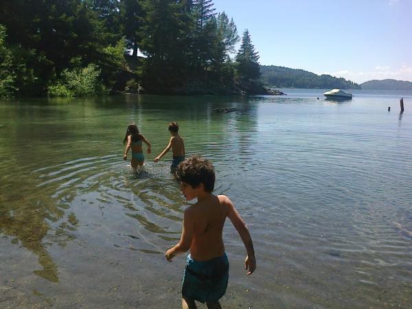 tres niños jugando al agua en un lago en Casa de Montaña Excelente Vista Pre-Viaje 2022 en San Carlos de Bariloche