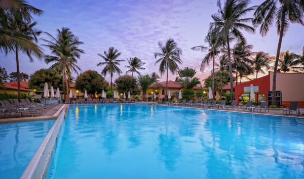 Large outdoor pool at Ocean Bay Hotel & Resort with palm trees and lounge chairs at dusk